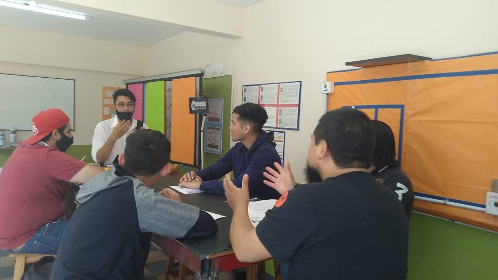 rofesor explicando diagramas de conexión eléctrica y normativas de seguridad sobre el pizarrón en el taller presencial de Global-T.