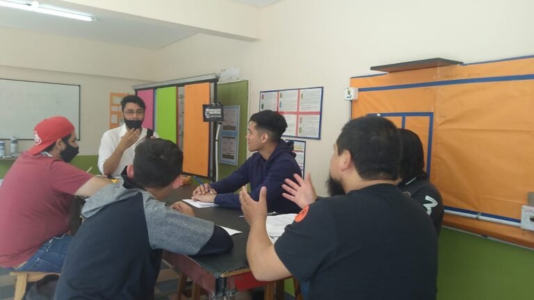 rofesor explicando diagramas de conexión eléctrica y normativas de seguridad sobre el pizarrón en el taller presencial de Global-T.