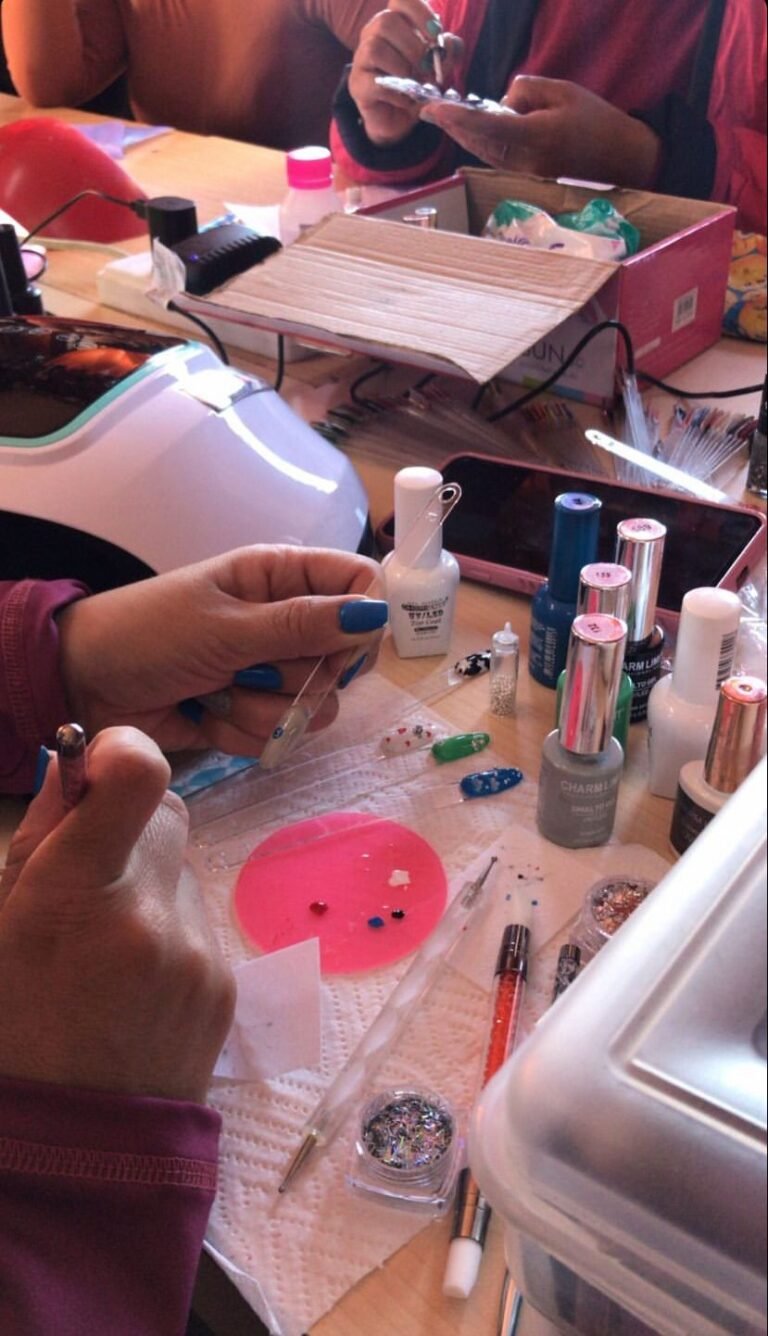 Mesa de trabajo del taller presencial con herramientas profesionales, lámpara UV para esmaltado semipermanente y tornos para uñas esculpidas en el aula de Global-T.